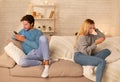 Indifferent Couple Using Mobile Phones Sitting On Couch At Home Royalty Free Stock Photo