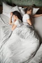 Indifferent millennial couple sleeping back to back after fight Royalty Free Stock Photo