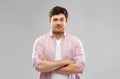 Indifferent young man with crossed hands over grey Royalty Free Stock Photo