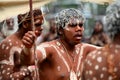 Indigenous Australian man holding traditional weapons during a ceremonial dance in Cape York Queensland Australia