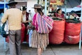 Indigenous Bolivian couple selling coca leaf at the market