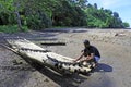 Indigenous Fijan man building a traditional Fijian bamboo boat