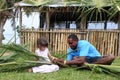 Indigenous Fijian man teach young tourist girl how to create a b Royalty Free Stock Photo