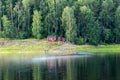 Indigenous salmon fishermen returning to their red Swedish cottage in the countryside with their boats with nets full of salmon