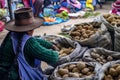Indigenous woman selling different types of potatoes