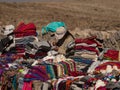 Indigenous woman selling traditional colorful handwoven wool textile clothing at road from Colca Canyon to Arequipa Peru