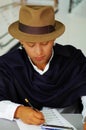 Indigenous young man writing notes to music with harmonica, concept of composition Royalty Free Stock Photo