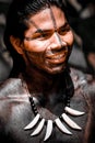 Indigenous young warrior wearing body and face paint and adornments