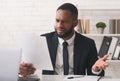 Indignant businessman reading reports in modern office Royalty Free Stock Photo