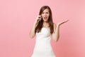 Indignant bride woman in white wedding dress have problem with planning wedding talking on mobile phone, swearing