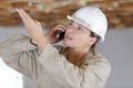 indignant construction female worker talking on mobile phone Royalty Free Stock Photo