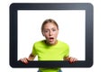 Indignant girl peeking through digital tablet frame