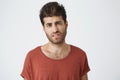 Really Indignant stylish boy with trendy haircut dressed in casual clothing standing at white studio wall, expressing