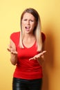 Indignant young woman on color background