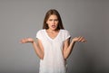 Indignant young woman on grey background