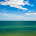 An indigo ocean and a bright blue sky with white clouds Royalty Free Stock Photo