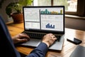 Individual engaging with interactive data interface, analyzing graphs and managing tasks on desktop