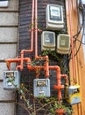 Individual gas and electric meters on the wall of a residential building