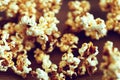 Individual golden flakes of delicious popcorn scattered on table.