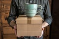 individual holding a box with a coffee mug on top