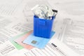 1040 Individual income tax return form and crumpled hundred dollar bill in trash bin on credit cards