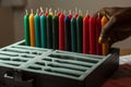 individual neatly storing a set of kwanzaa candles in a foam insert box Royalty Free Stock Photo