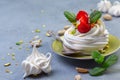 Individual Pavlova cakes with strawberries, pistachios and mint Royalty Free Stock Photo