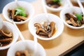 individual portions of marinated mushrooms, tasting spoons