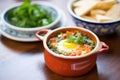 individual serving, shakshuka in ramekin, fresh herbs on top