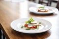 individual servings of eggplant parmesan on white plates