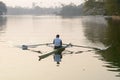 Individual Sports Speed Rower in Single scull crew rowing boat sliding racing shell on lake water oars in motion sitting sliding