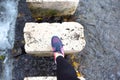 Individual stepping on stone path over flowing water in natural setting Royalty Free Stock Photo