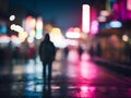 An individual is strolling down a rain-soaked street under the night sky illuminated Royalty Free Stock Photo