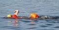 Swimmer in the bay with yellow swim cap and orange flotation