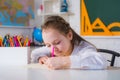 Individual teaching. Cute little girl drawing at home Cute child boy with teacher in classroom near blackboard desk. Royalty Free Stock Photo