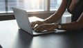 Woman working with laptop at black desk in office, closeup Royalty Free Stock Photo