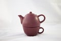 Maroon ceramic teapot on white background