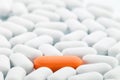 Individuality - Orange pill between white ones Royalty Free Stock Photo