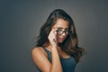 Individuality is so sexy. Studio shot of an attractive young woman peering over her glasses against a grey background. Royalty Free Stock Photo