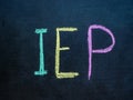 Individualized Education Program IEP written in chalk on blackboard.