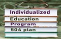 INDIVIDUALIZED EDUCATION PROGRAM 504 PLAN - words are written on books on a dark background