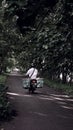 Yogyakart, December 20, 2020: the old man riding a motorbike on a deserted road. Royalty Free Stock Photo