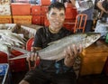 Indonesia, June 13 2022 - Man proudly holds large fish he is selling at the market