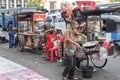 Indonesia man prepares food at a vintage metal street food push cart in Jakarta, Indonesia