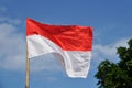 Indonesias red and white flag flying against blue sky Royalty Free Stock Photo