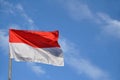 Indonesias red and white flag flying against blue sky Royalty Free Stock Photo