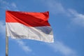 Indonesias red and white flag flying against blue sky Royalty Free Stock Photo