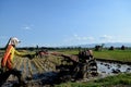 An Indonesian farmer ploughing a rice paddy rield in Golan Village