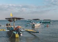 An indonesian fishing man inspecting his jukung fishing boat in kuta bali