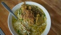 Indonesian food soto in a bowl placed in a wooden table